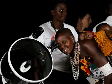 Seorang wanita suku Maasai menggunakan teleskop melihat fenomena supermoon di desa Oloika, Shompole, perbatasan Kenya-Tanzanian border, (14/11). Fenomena ini merupakan bulan paling besar dan terang dalam kurun 70 tahun terakhir. (REUTERS/Thomas Mukoya)