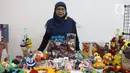 Perajin berpose dengan karya buatannya selama acara Gebyar Ekraf di Bogor Creative Center, Kota Bogor, Minggu (11/12/2022). Gebyar Ekraf di berlangsung pada 10-11 Desember 2022. (Liputan6.com/Magang/Aida Nuralifa)