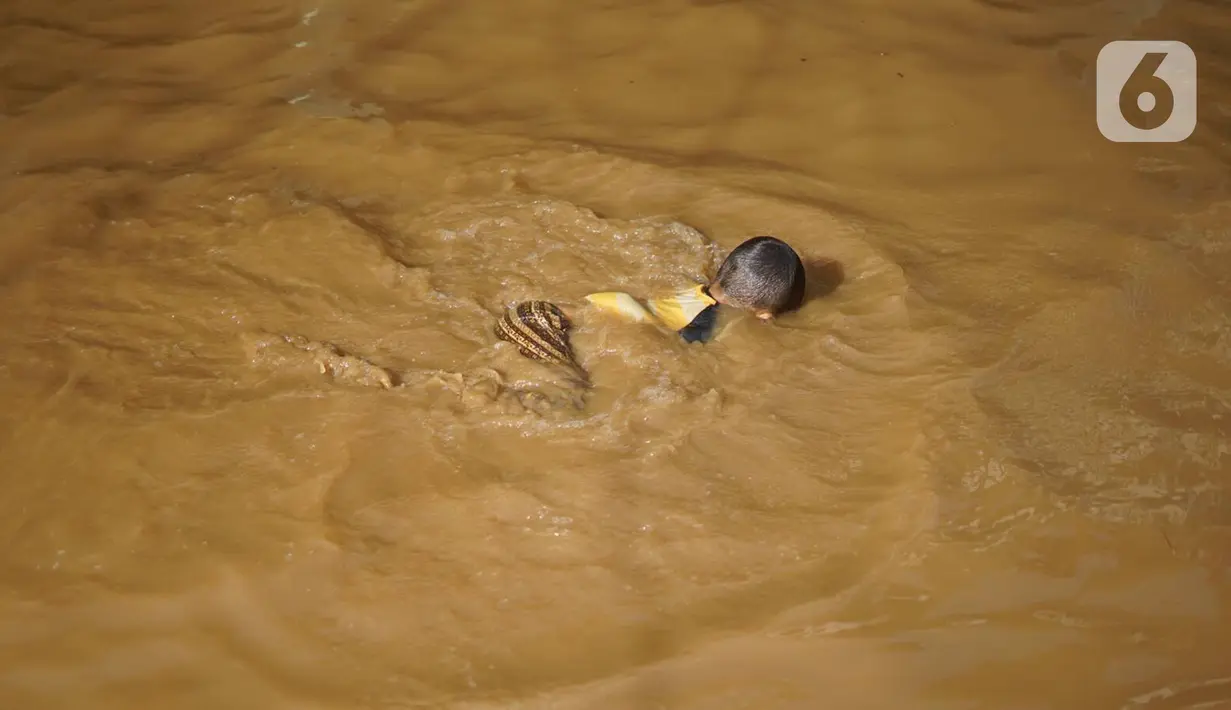 Anak-anak berenang di tengah banjir yang merendam kawasan Rawajati, Jakarta Selatan, Sabtu (8/2/2020). Hujan yang terjadi semalaman menyebabkan Sungai Ciliwung kembali meluap hingga membuat rumah warga di kawasan tersebut terendam air setinggi 50 cm hingga 1 m. (Liputan6.com/Immanuel Antonius)
