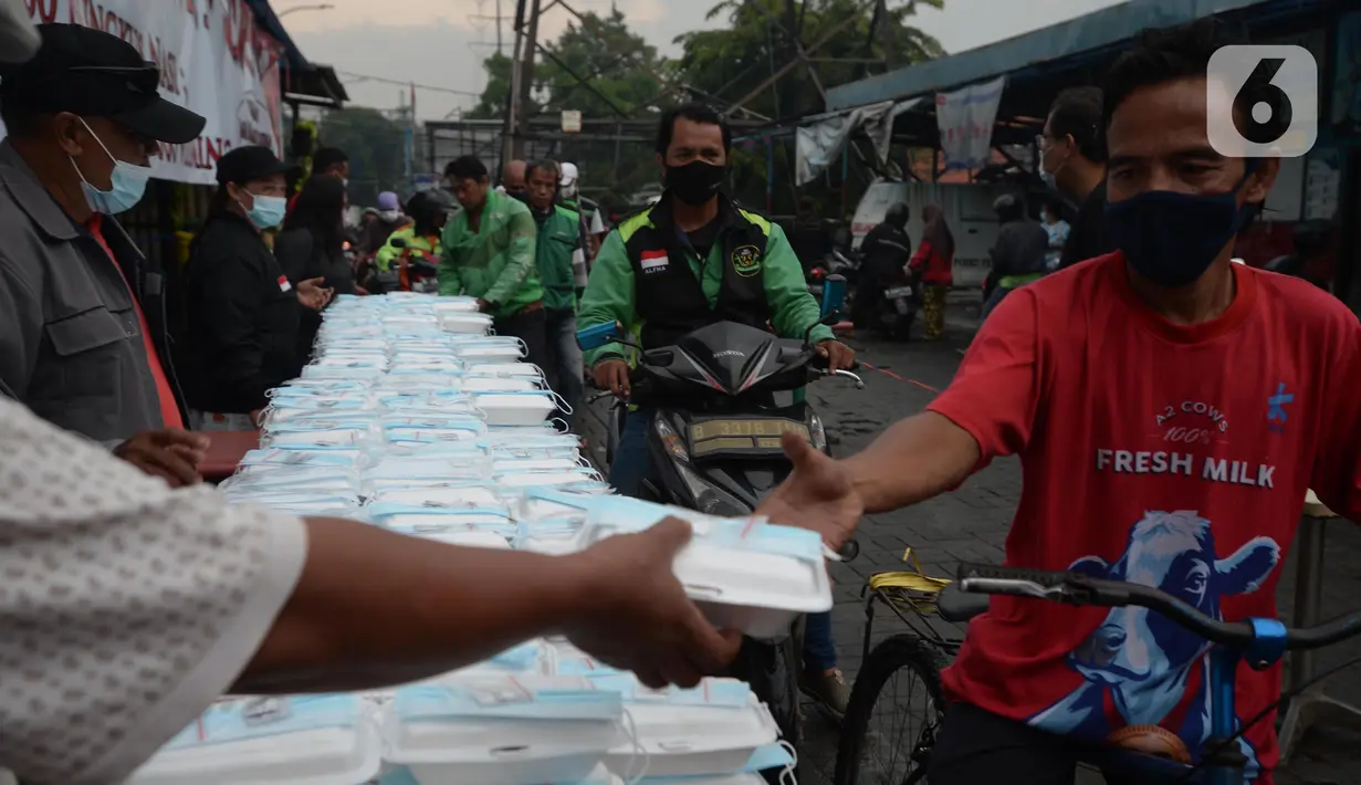 Warga menerima pembagian nasi bungkus gratis di Posko Perjuangan Rakyat (POSPERA), Jakarta, Rabu (10/3/2021). Pembagian 500 nasi bungkus beserta masker dan vitamin secara gratis setiap harinya dalam bentuk meringankan beban warga di tengah pandemi Covid-19. (merdeka.com/Imam Buhori)