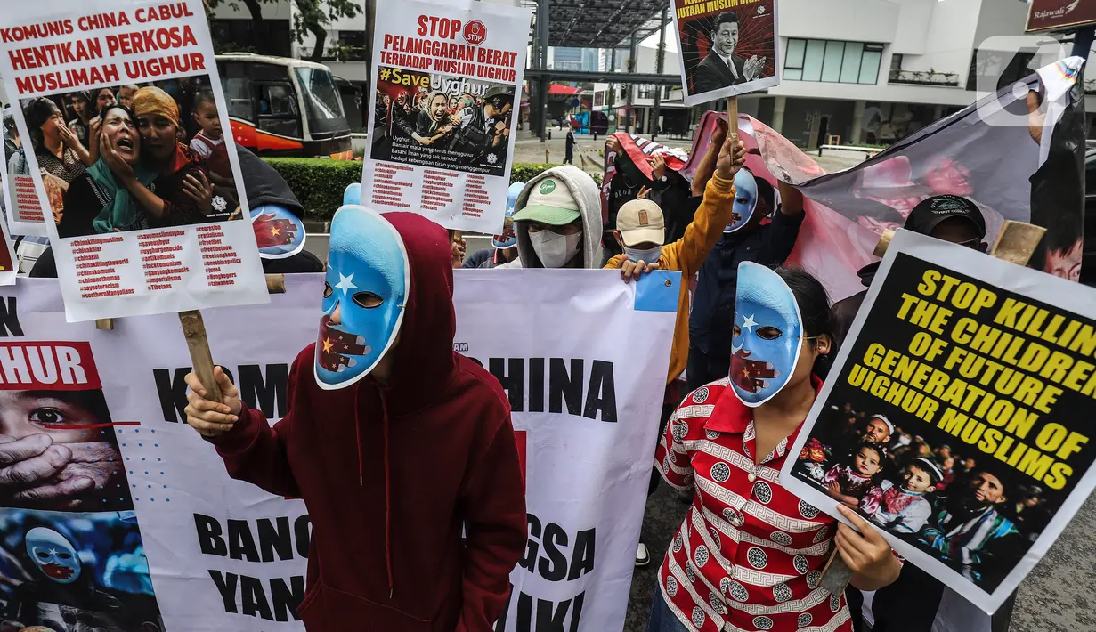Mahasiswa mengenakan topeng dan membawa poster saat aksi demonstrasi di depan Kedutaan Besar (Kedubes) China, Jakarta, Jumat (30/9/2022). Dalam demo tersebut mahasiswa menuntut pemerintah China untuk menghentikan kekerasan terhadap umat muslim di China khususnya di Uighur serta masyarakat Tibet, Mongolia, Hongkong dan Taiwan. (Liputan6.com/Johan Tallo)