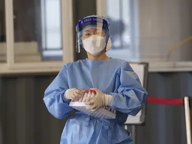 Pekerja medis mengenakan alat pelindung bersiap untuk mengambil sampel di klinik skrining sementara untuk virus corona di Seoul, Korea Selatan, Jumat (24/9/2021). Korea Selatan telah melaporkan lonjakan harian terbesar virus corona sejak dimulainya pandemi. (AP Photo/Lee Jin-man)