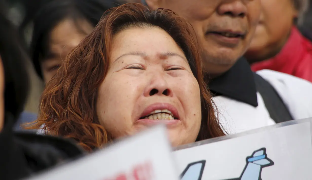 Keluarga penumpang pesawat Malaysia Airlines MH370 berunjuk rasa membawa poster di Lama Temple, Beijing, Cina, (8/3). Poster Tersebut bertuliskan "Ibu akan selalu menunggu. Tidak akan menyerah." (REUTERS/Kim Kyung-hoon)