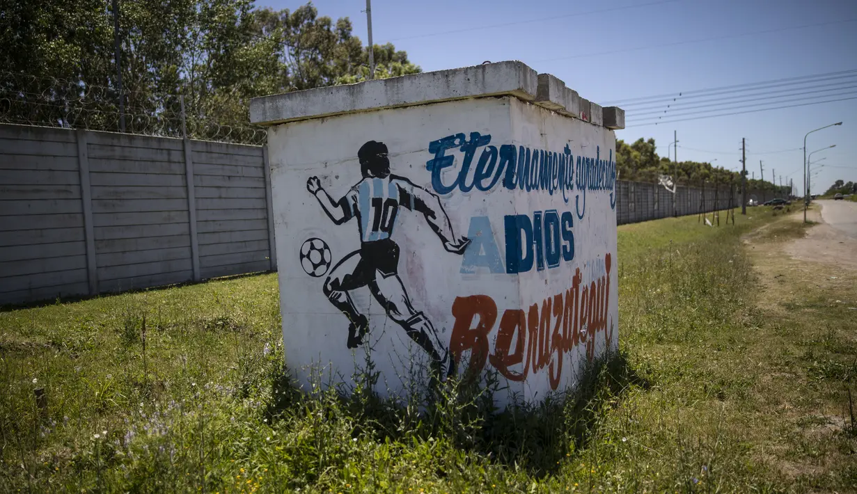 Sebuah mural mendiang legenda sepak bola dunia, Diego Maradona berdiri di samping jalan raya di Buenos Aires, Argentina, Rabu (24/11/2021). Peringatan pertama kematian Maradona digelar pada 25 November 2021. (AP Photo/Rodrigo Abd)