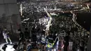 Orang-orang yang memakai masker wajah untuk membantu melindungi dari penyebaran virus korona, melihat pemandangan malam Seoul saat mereka menginap di tempat berkemah semalam di atap gedung pencakar langit di Seoul, Korea Selatan (7/8/2020).  (AP Photo/Lee Jin-man)