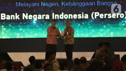 Gubernur Bank Indonesia Perry Warjiyo menyerahkan penghargaan ke Direktur Teknologi Informasi dan Operasi BNI Dadang Setiabudi di Jakarta, (28/11/2019). BNI meraih  penghargaan BI award kategori peserta BI-RTGS dan BI-SSSS terbaik serta peserta SKNBI dan KPDHN terbaik. (Liputan6.com/Angga Yuniar)