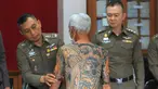 Petugas menunjukkan tato Mantan bos Yakuza asal Jepang, Shigeharu Shirai di sebuah kantor polisi saat konferensi pers di Lopburi, Thailand, Kamis, (11/1). Pria 72 tahun ini ditangkap setelah 14 tahun menjadi buronan. (AP Photo)
