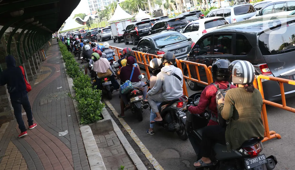 Warga bersama kendaraan antre memasuki kawasan Taman Impian Jaya Ancol, Jalarta, Kamis (29/10/2020). Selain tingginya minat warga berwisata di masa libur panjang, antrean ini juga disebabkan pengalihan buka tutup pintu masuk kawasan Taman Impian Jaya Ancol.  (Liputan6.com/Helmi Fithriansyah)