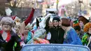 Aktris Mila Kunis (tengah) dicium oleh Amira Weeks (kiri) dan Jacques Berguig dalam sebuah parade di Cambridge (25/1). (AP Photo / Charles Krupa)