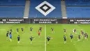 Para pemain timnas Rumania melakukan pemanasan selama sesi latihan di Hamburg, Jerman, Kamis (7/10/2021). Timnas Rumania akan menantang Jerman dalam laga lanjutan Grup J Kualifikasi Piala Dunia 2022 zona Eropa di Volksparkstadion, Sabtu dini hari WIB. (John MACDOUGALL/AFP)