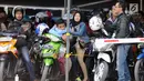 Sejumlah pemudik di atas motor saat menanti waktu masuk kapal penyereberangan di Dermaga 6 Pelabuhan Merak, Banten, Kamis (22/6). Dini hari, ribuan pemudik bermotor menyeberang dari Merak menuju Bakauheni, Lampung. (Liputan6.com/Helmi Fithriansyah)