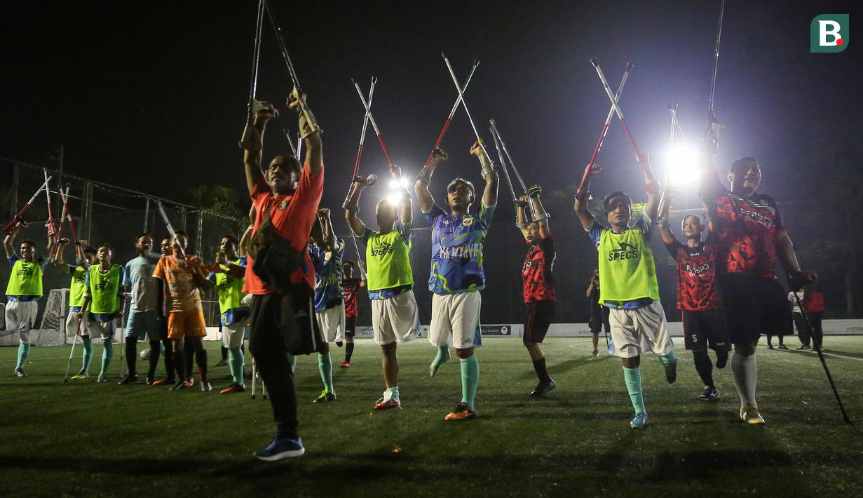 Pemain Timnas Sepak Bola Amputasi Indonesia dan pemain Persaj Jakarta memberikan salam penghormatan untuk para suporter yang telah hadir pada laga uji coba untuk persiapan Piala Dunia Amputasi 2022 di Serenia Hills Mini Soccer, Jakarta Selatan, Senin (08/08/2022). Garuda INAF menang dengan skor 13-0. (Bola.com/Bagaskara Lazuardi)