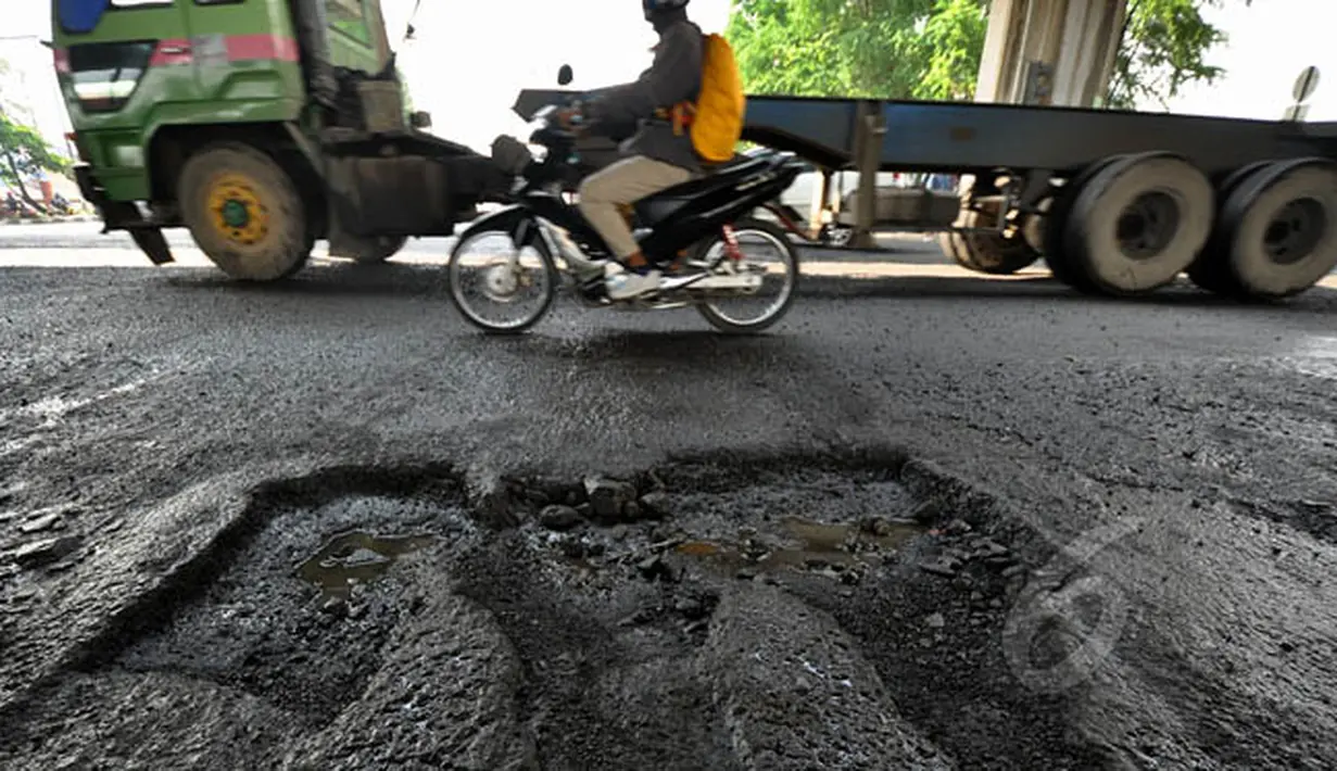 Kondisi jalanan yang rusak di Jalan R.E Martadinata, Jakarta, Senin (16/2/2015). Hujan deras serta ruas jalan yang terendam air mengakibatkan badan jalan menjadi rusak dan berlubang. (Liputan6.com/Faizal Fanani)