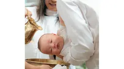 Ketika menjalani proses pembaptisan, Baby Oliver sangat anteng digendongan sang ayah. Dalam foto ini terlihat Pamela Bowie yang berdiri di dekat sang suami ketika pembaptisan sang anak berlangsung. Kepalanya disiram dengan air, Baby Oliver tampak nyaman sembari memejamkan mata. Unggahan proses pembaptisan di Instagram, Pamela Bowie mematikan kolom komentar unggahannya. (Liputan6.com/IG/@pammybowie)
