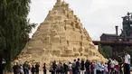 Seniman saat menyelesaikan istana pasir di Landschaftspark di Duisburg, Jerman , (1/9). Seniman dari Duisburg burusaha meraih Guinness Book of World Records dengan membuat istana pasir tertinggi yang pernah ada. (Marcel Kusch / dpa via AP)