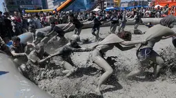 Sejumlah orang bermain di kolam lumpur selama Festival Lumpur Boryeong di Pantai Daecheon di Boryeong, Korea Selatan, (14/7). Festival lumpur tahunan ke-21 ini menampilkan gulat lumpur. (AP Photo / Ahn Young-joon)