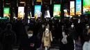 <p>Orang-orang yang memakai masker berjalan di stasiun Shinagawa di Tokyo (18/1/2022). Jepang melaporkan rekor tertinggi infeksi Covid-19 baru yang dipicu oleh varian Omicron. (AFP/Philip Fong)</p>