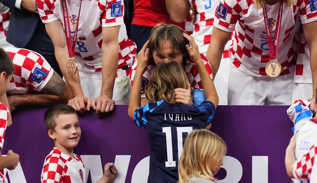 Kapten Kroasia, Luka Modric mencium anaknya, Ivano saat timnya berhasil menyabet peringkat ketiga Piala Dunia 2022 setelah mengalahkan Maroko dengan skor 2-1 pada laga yang berlangsung di Khalifa International Stadium, Doha, Qatar, Sabtu (17/12/2022). (AP Photo/Hassan Ammar)