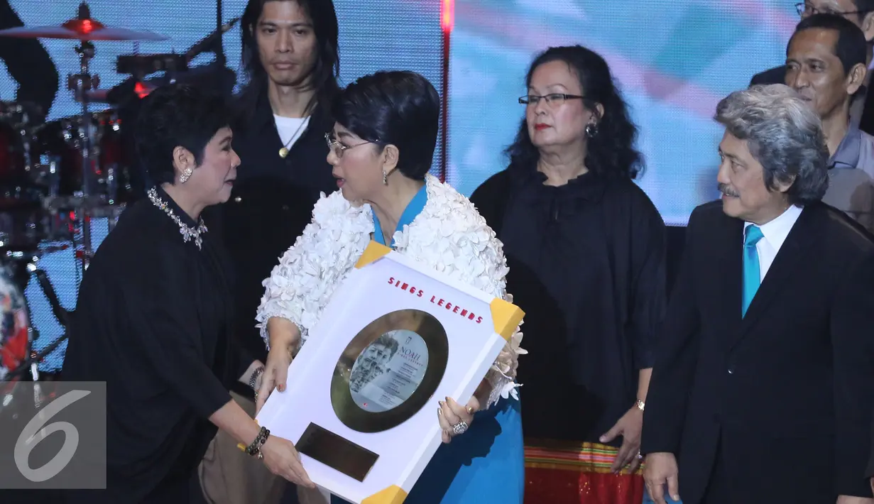 Direktur Utama Musica Studios Indrawati Widjaja memberikan plakat 'Sings Legends'  ke penyanyi Titiek Puspa saat konser The Biggest Concert Noah 'Sings Legends'  di Studio 6 Emtek City, Jakarta, Kamis (19/5).  (Liputan6.com/Herman Zakharia)