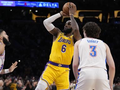 Bintang LA Lakers, LeBron James sukses pecahkan rekor Kareem Abdul Jabbar sebagai pemain NBA dengan perolehan poin terbanyak sepanjang masa. Rekor fenomenal tersebut dicatatkannya saat LA Lakers menghadapi Oklahoma City Thunder di Crypto.com Arena, Los Angeles, Rabu (8/2/2023) pagi WIB. Dalam laga tersebut LeBron James total mengemas 38 poin, sehingga total mengoleksi 38.390 poin sepanjang kariernya di NBA, melewati torehan Kareem Abdul Jabbar yang total mengumpulkan 38.387 poin. (AP Photo/Ashley Landis)