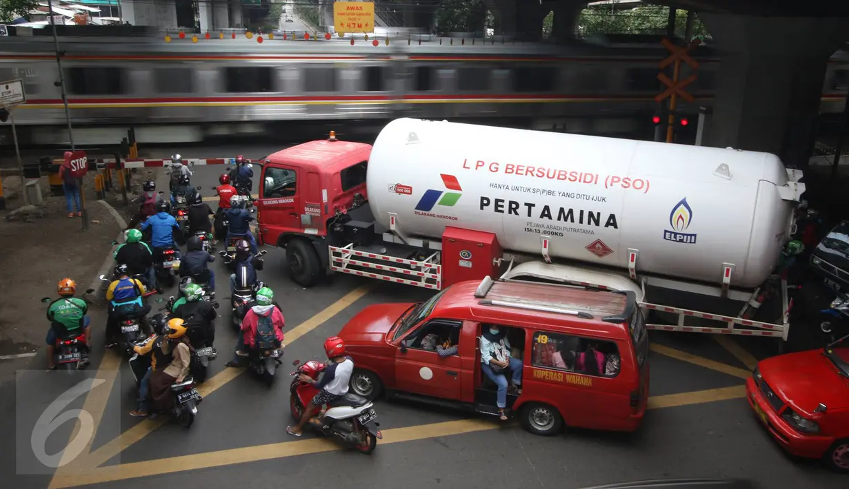 Kendaraan menunggu kereta melintas di kawasan Tanjung Barat, Jakarta, Rabu (8/3). Perlintasan yang akan ditutup yaitu perlintasan Jalan Pejompongan I, perlintasan Jalan Pasar Minggu. (Liputan6.com/Immanuel Antonius)