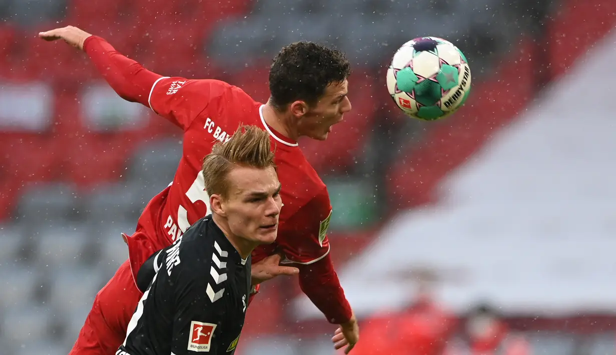 Bek Freiburg, Philipp Leinhart (depan) berebut bola dengan bek Bayern Munich, Benjamin Pavard dalam laga lanjutan Liga Jerman 2020/21 pekan ke-16 di Allianz Arena, Minggu (17/1/2021). Freiburg kalah 1-2 dari Bayern Munich. (AFP/Christof Stache/Pool)