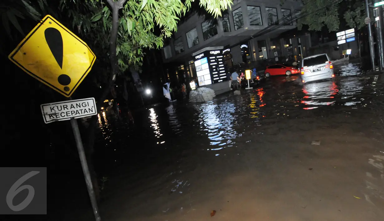 Kendaraan roda empat melintasi jalanan yang tergenang banjir di kawasan Kemang, Jakarta, Minggu (25/9). Hujan deras yang mengguyur sebagian besar kawasan di Jakarta, Minggu malam, membuat wilayah Kemang terendam banjir lagi. (Liputan6.com/Helmi Afandi)