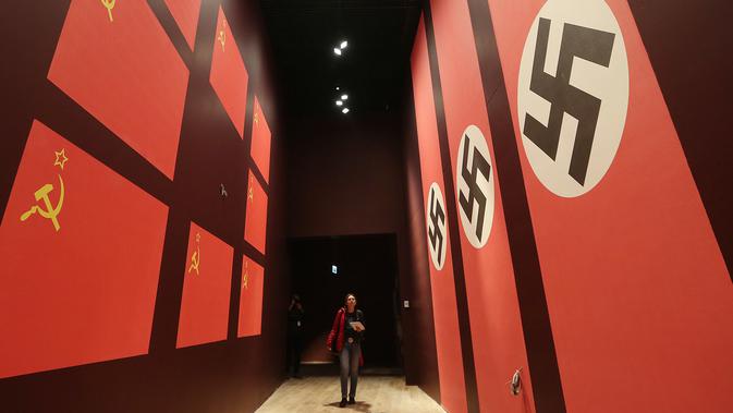 Pengunjung melintas dilorong bergambarkan bendera Nazi dan Soivet di Museum Perang Dunia 2 di Gdansk, Polandia, 23/1). Museum ini satu-satunya yang merekam sejarah Polandia saat Perang Dunia II. (AP/Czarek Sokolowski)