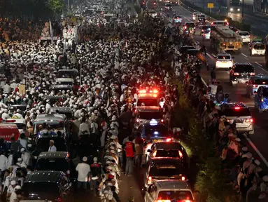 Massa peserta demo 4 November dan kendaraan memadati Jalan Gatot Subroto, Jakarta atau tepat di depan Gedung MPR/DPR RI, Jumat (4/11). Mereka menginap di jalan depan Gedung DPR lantaran tak diizinkan masuk ke komplek parlemen (Liputan6.com/Johan Tallo)