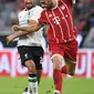 Gelandang Liverpool, Emre Can (kiri) berebut bola dengan gelandang Munchen, Javi Martinez saat bertanding di semifinal Audi Cup di Allianz Arena di Munich, Jerman (1/8). Liverpool menang 3-0 atas Munchen. (Christof Stache/AFP)