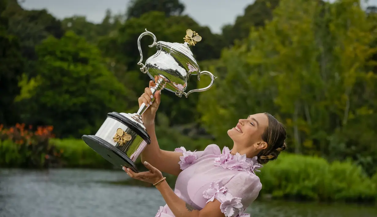 Petenis Belarusia, Aryna Sabalenka berpose dengan trofi kejuaraan tenis Australia Open 2023 di Royal Botanic Garden di Melbourne, Minggu (29/1/2023). Sabalenka yang berusia 24 tahun menang atas Elena Rybakina dari Kazakhstan di final 4-6, 6-3 dan 6-4. (AP Photo/Aaron Favila)