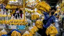 Seorang pria membawa bunga marigold menjelang Loy Krathong di pasar bunga Pak Khlong Talat, Bangkok, Kamis (18/11/2021). Bulan November ini Thailand akan mengadakan festival Loy Krathong di mana warga akan menghanyutkan keranjang berisi bunga dan lilin di sungai, kolam atau danau. (Jack TAYLOR/AFP)