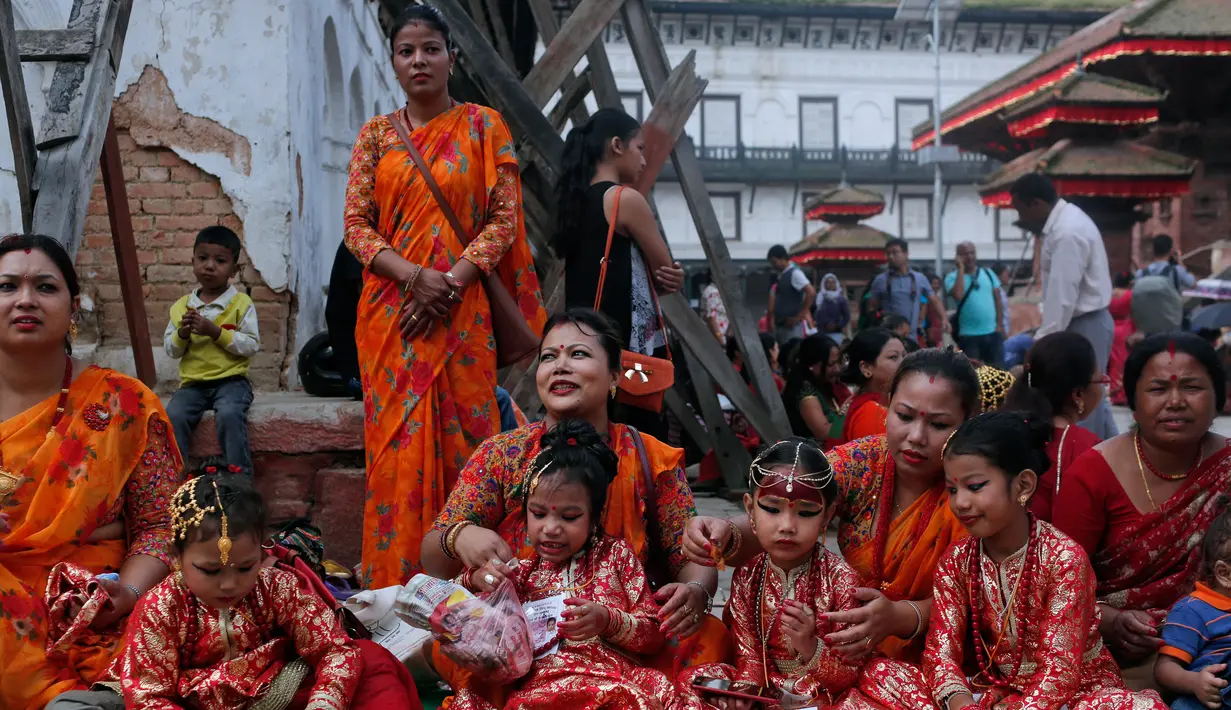 Wanita-wanita Nepal bersama putrinya menunggu acara pemujaan Kumari di Hanuman Dhoka, Kathmandu, Nepal, Senin (4/9). Dewi Kumari diyakini hidup ditubuh anak perempuan yang belum pada masa pubertas. (AP Photo/Niranjan Shrestha)