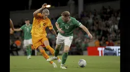 Pemain Timnas Belanda, Wout Weghorst (kiri), berusaha melewati pemain Timnas Irlandia Nathan Collins, dalam pertandingan grup B Kualifikasi Euro 2024 yang berlangsung di Aviva Stadium, Dublin, Senin (11/9/2023) dini hari WIB. (AP/PA/Donall Farmer)