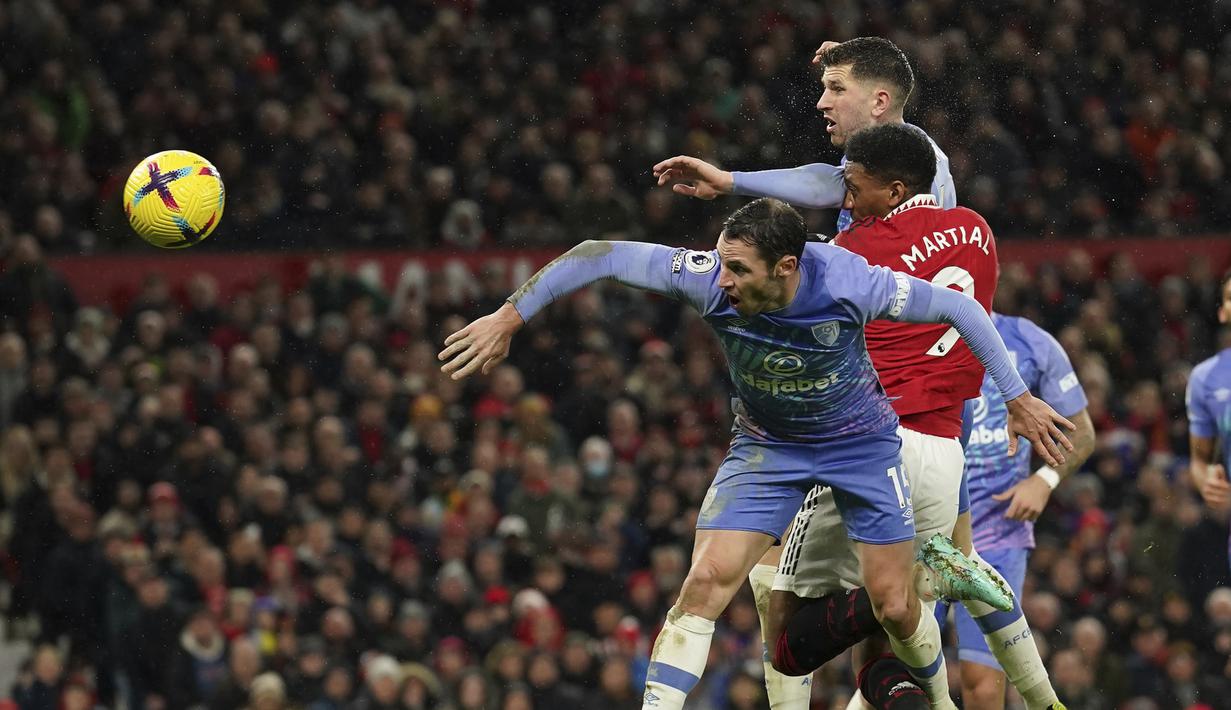 Penyerang Manchester United, Anthony Martial menyundul bola dari kawalan dua pemain Bournemouth pada pertandingan lanjutan Liga Inggris di Old Trafford di Manchester, Inggris, Rabu (4/1/2023). Bournemouth tertahan di posisi ke-15 dengan 16 poin. (AP Photo/Dave Thompson)