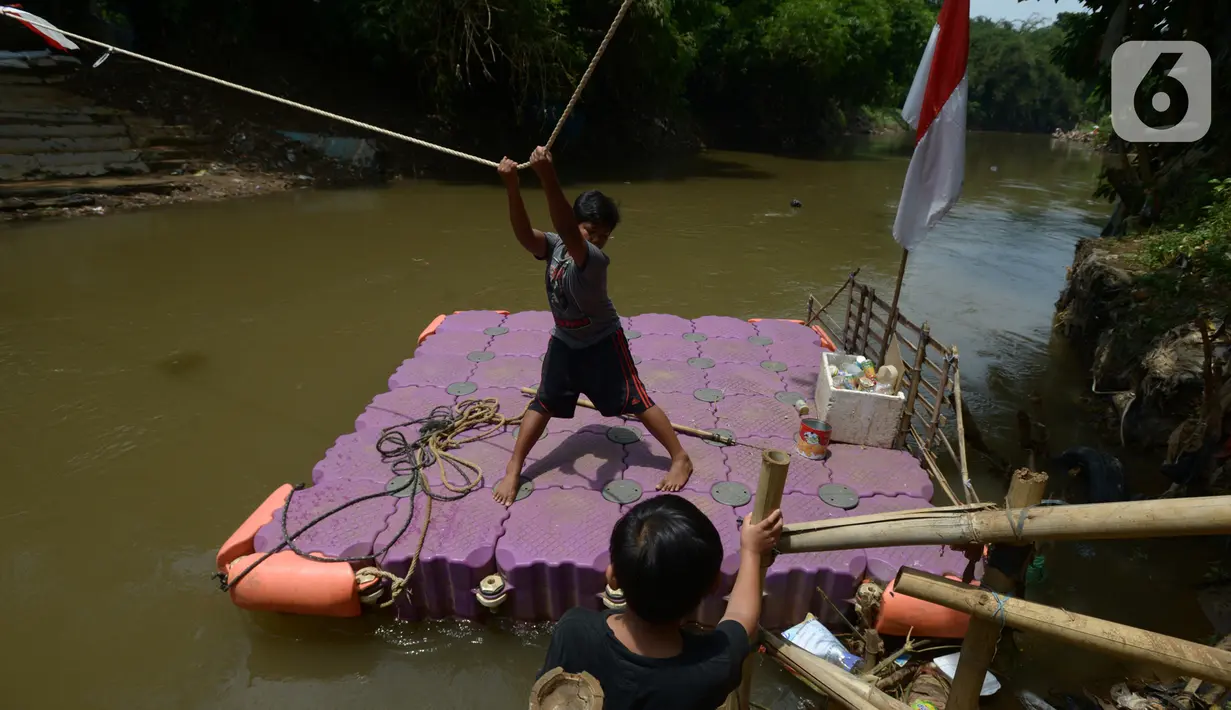 Anak-anak menggunakan perahu eretan di sungai Ciliwung, Jakarta, Selasa (3/11/2020). Perahu eretan di sungai Ciliwung masih bertahan sebagai penghubung Jakarta Timur dan Jakarta Selatan Selatan. (merdeka.com/Imam Buhori)