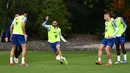 Gelandang Chelsea, Eden Hazard (tengah) menggiring bola saat mengikuti sesi latihan tim di Chelsea Training Ground, di Cobham, Surrey (22/5/2019). Chelsea akan bertanding melawan Arsenal pada babak Final Liga Europa pada 29  Mei di Baki Olimpiya Stadionu. (AFP Photo/Ben Stansall)