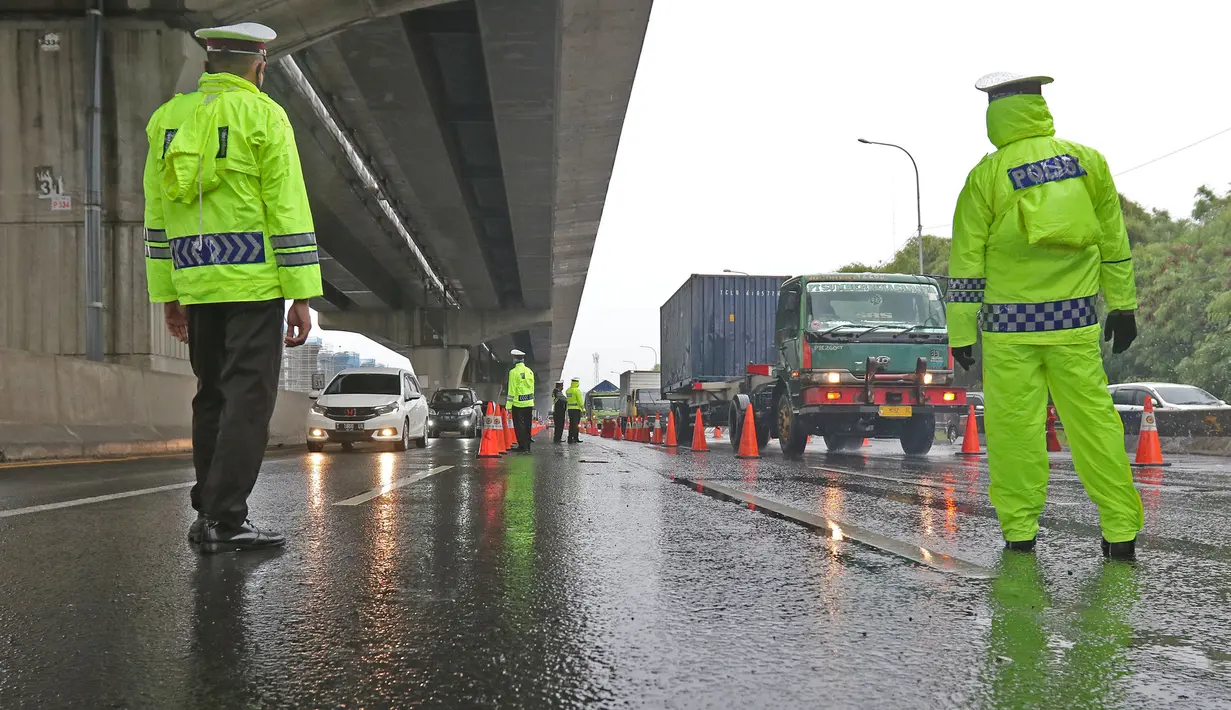 Petugas kepolisian berjaga di Pos Penyekatan Jalur Mudik di Gerbang Tol Cikarang Barat, Kabupaten Bekasi, Senin (18/5). Memasuki H-6 Lebaran, puluhan kendaraan diminta untuk putar balik karena melanggar larangan mudik sebagai upaya memutus rantai penyebaran Covid-19. (Liputan6.com/Herman Zakharia)