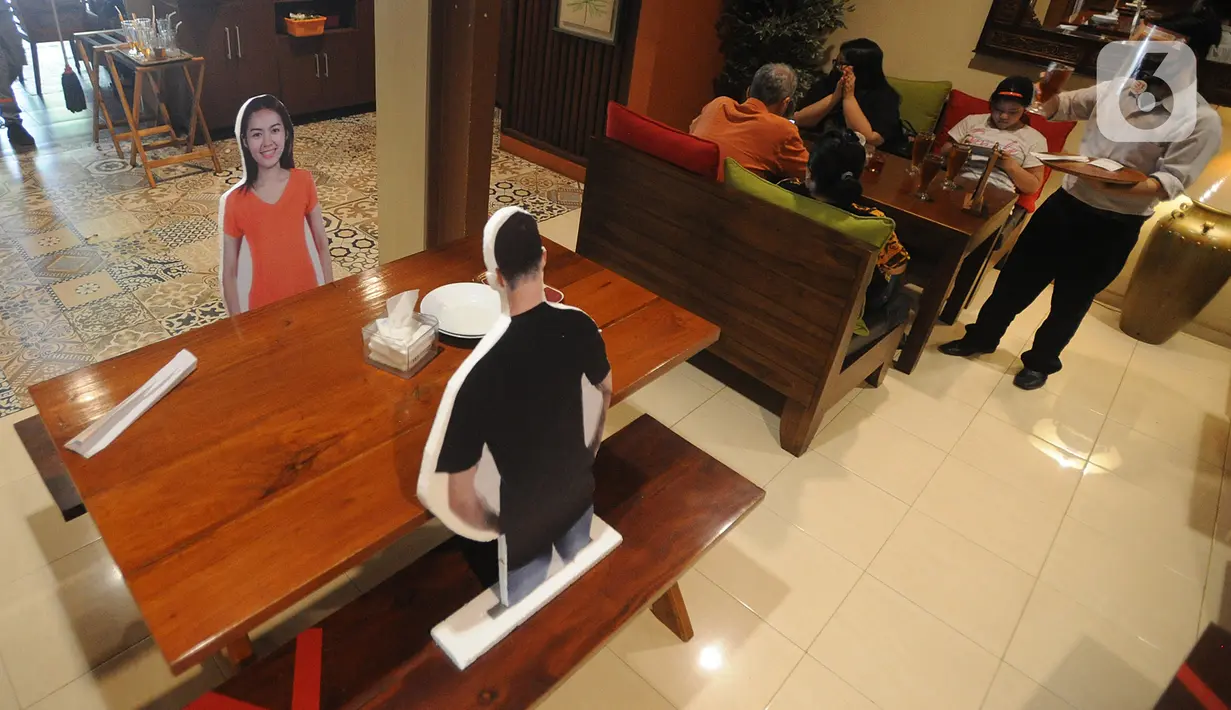 Pramusaji menggunakan pelindung wajah, masker dan sarung tangan di Rumah Makan Bumi Aki, Pajajaran, Kota Bogor, Minggu  (31/5/2020). Sejumlah restoran dan rumah makan di Bogor mulai membuka layanan makan di tempat dengan protokol kesehatan ketat guna mengatasi COVID-19. (merdeka.com/Arie Basuki)