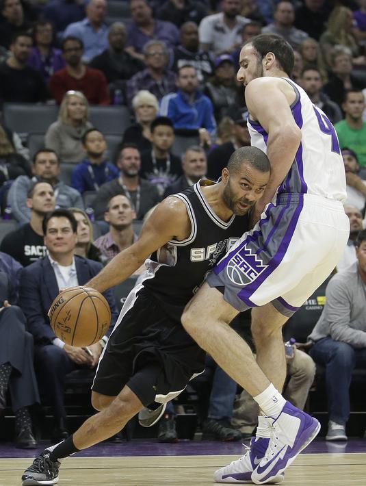 Pemain San Antonio Spurs, Tony Parker (kiri), berusaha melewati pemain Sacramento Kings, Kosta Koufos, dalam laga reguler NBA 2016-2017 di Golden 1 Center, Sacramento, Kamis (17/11/2016) WIB. (AP Photo/Rich Pedroncelli)