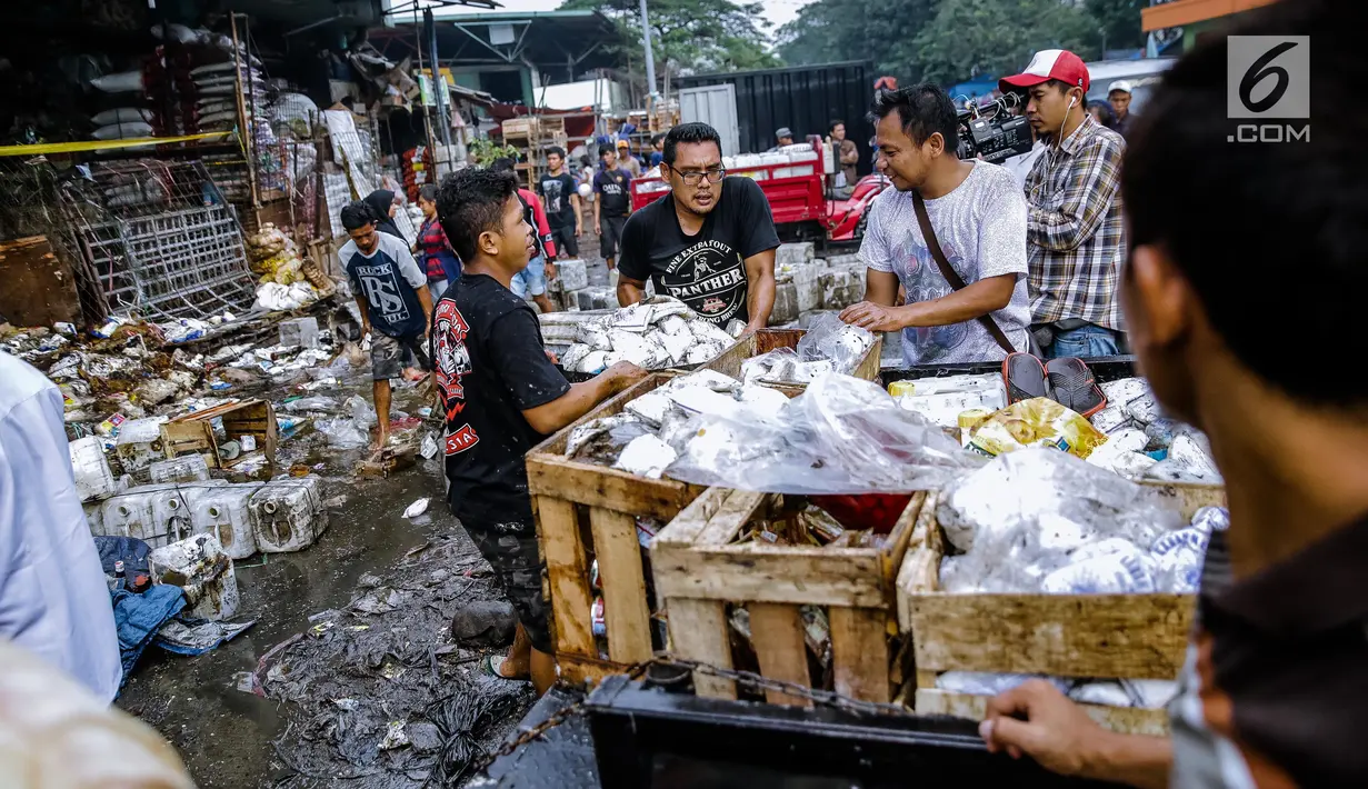 Sejumlah pedagang menyelamatkan barang dagangannya dari lokasi Pasar Induk Kramat Jati Blok C1, Jakarta Timur, yang terbakar, Senin (12/6). Sebanyak 19 unit mobil pemadam kebakaran diterjunkan untuk memadamkan api. (Liputan6.com/Faizal Fanani)