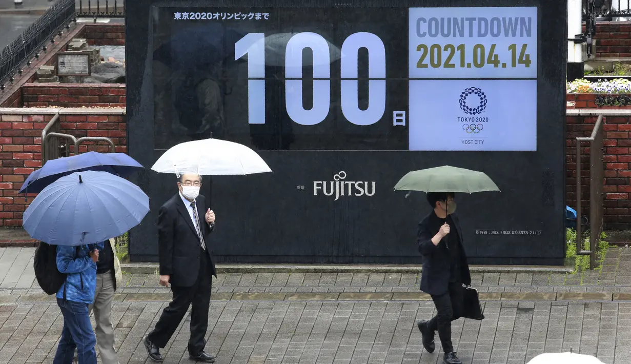 Orang-Orang berjalan di dekat jam hitung mundur untuk Olimpiade dan Paralimpiade Tokyo untuk menandai 100 hari sebelum dimulainya olimpiade musim panas di Tokyo, Rabu (14/4/2021). Olimpiade Tokyo akan dibuka pada 23 Juli 2021. (AP Photo/Koji Sasahara)