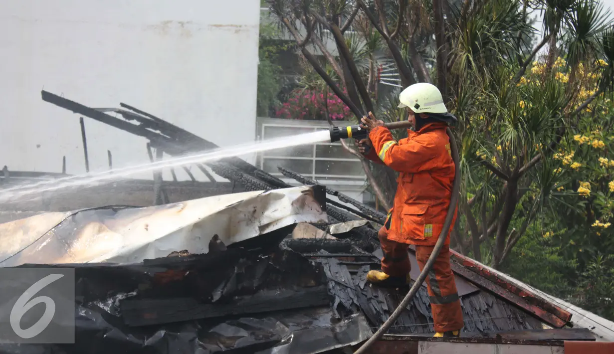 Petugas tampak menyemprotkan air untuk memadamkan api yang membakar rumah yang dijadikan Sekretariat RT,  Kebayoran Baru, Jakarta Selatan, Rabu (26/08/15). Polisi masih menyelidiki akibat kebakaran tersebut. (Liputan6.com/Gempur M Surya)