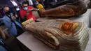 Sejumlah orang mengabadikan foto peti mati kuno yang baru ditemukan di situs pemakaman Saqqara di Provinsi Giza, Mesir, 3 Oktober 2020. Kementerian Pariwisata dan Kepurbakalaan Mesir memamerkan 59 peti mati kuno yang baru ditemukan dengan kondisi terawat baik di Provinsi Giza. (Xinhua/Ahmed Gomaa)