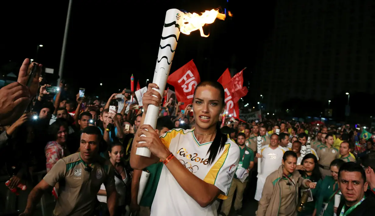 Supermodel Adriana Lima membawa obor pada malam penyambutan Olimpiade Rio 2016 di Maua Square Rio de Janeiro, Brasil, Kamis (4/8). (REUTERS / Pilar Olivares)