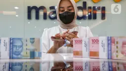 Teler menghitung mata uang rupiah di Jakarta, Jumat (3/3/2023). Sebelumnya, mata uang rupiah dibuka melemah ke posisi Rp15.291 di hadapan dolar AS pada perdagangan hari ini, Jumat (3/3/2023) dihadapan dolar AS. (Liputan6.com/Angga Yuniar)