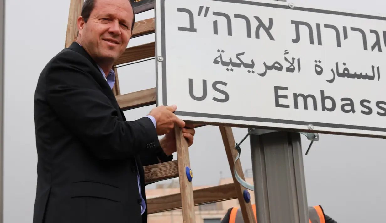 Wali Kota Yerusalem, Nir Barkat berpose dengan papan penunjuk jalan menuju Kedutaan Besar Amerika Serikat (AS) yang telah dipasang di Yerusalem, Senin (7/5). Papan itu bertuliskan bahasa Inggris, Ibrani, dan Arab. (Jerusalem Municipality via AP)