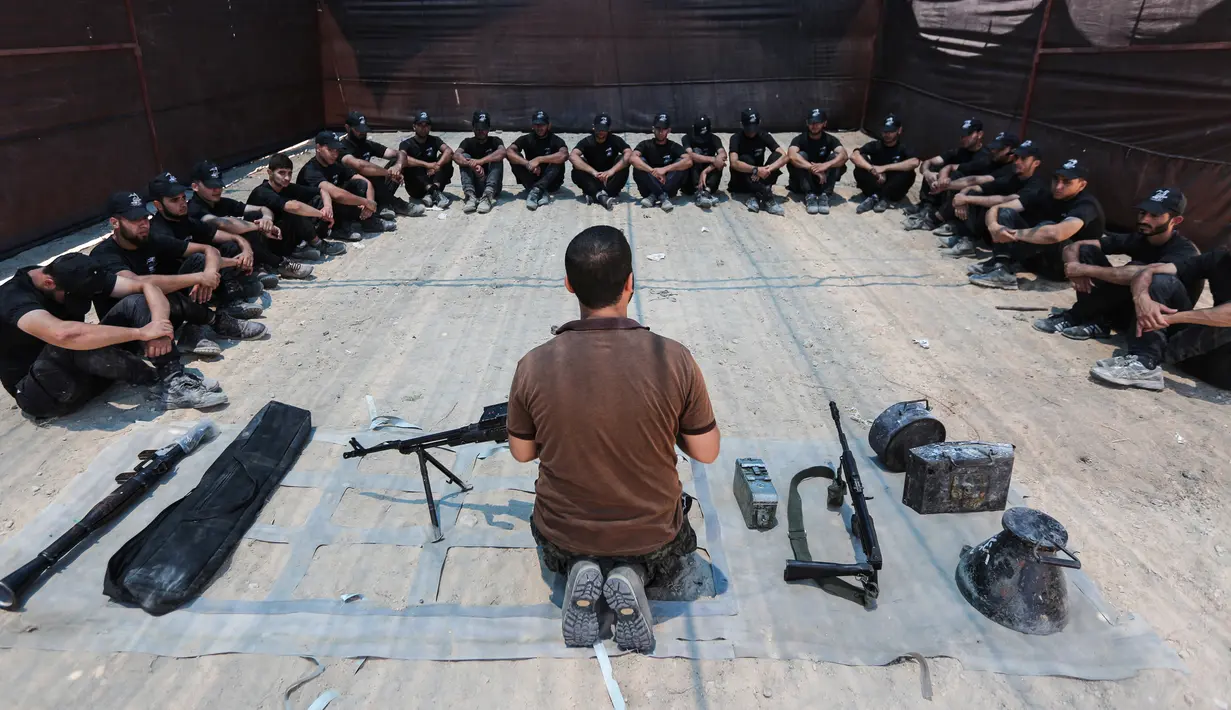 Sejumlah kadet Palestina mendapat pengarahan sebelum berlatih dengan militer Hamas, Brigade Ezzedin al-Qassam, di Kota Gaza (20/7/2019). Serangkaian tes militer pun harus dilakukan para kadet yang dimulai dari uji fisik, ketangkasan hingga menembak. (AFP Photo/Mahmud Hams)