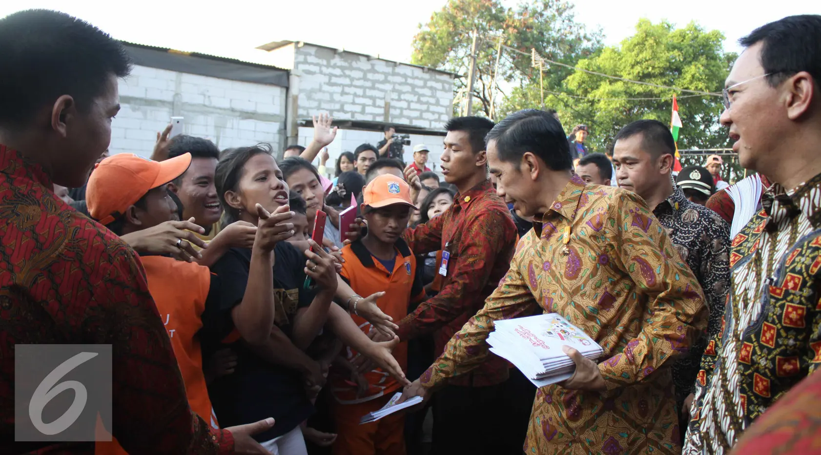 Presiden Jokowi ditemani Gubernur Ahok membagikan buku tulis, Jakarta, Kamis (3/9/2015). Presiden Jokowi bersama Gubernur Ahok mengadakan blusukan dan membagikan semabko pada warga di kawasan Cilincing. (Liputan6.com/Gempur M Surya)