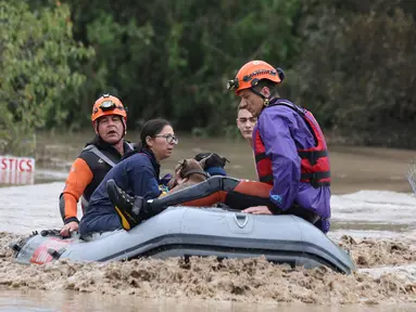 Petugas pemadam kebakaran dengan perahu karet mengevakuasi orang-orang dan hewan peliharaan dari sebuah bangunan yang terendam banjir di Larissa, Yunani Tengah, Rabu, 6 September 2023. (AP Photo/Vaggelis Kousioras)